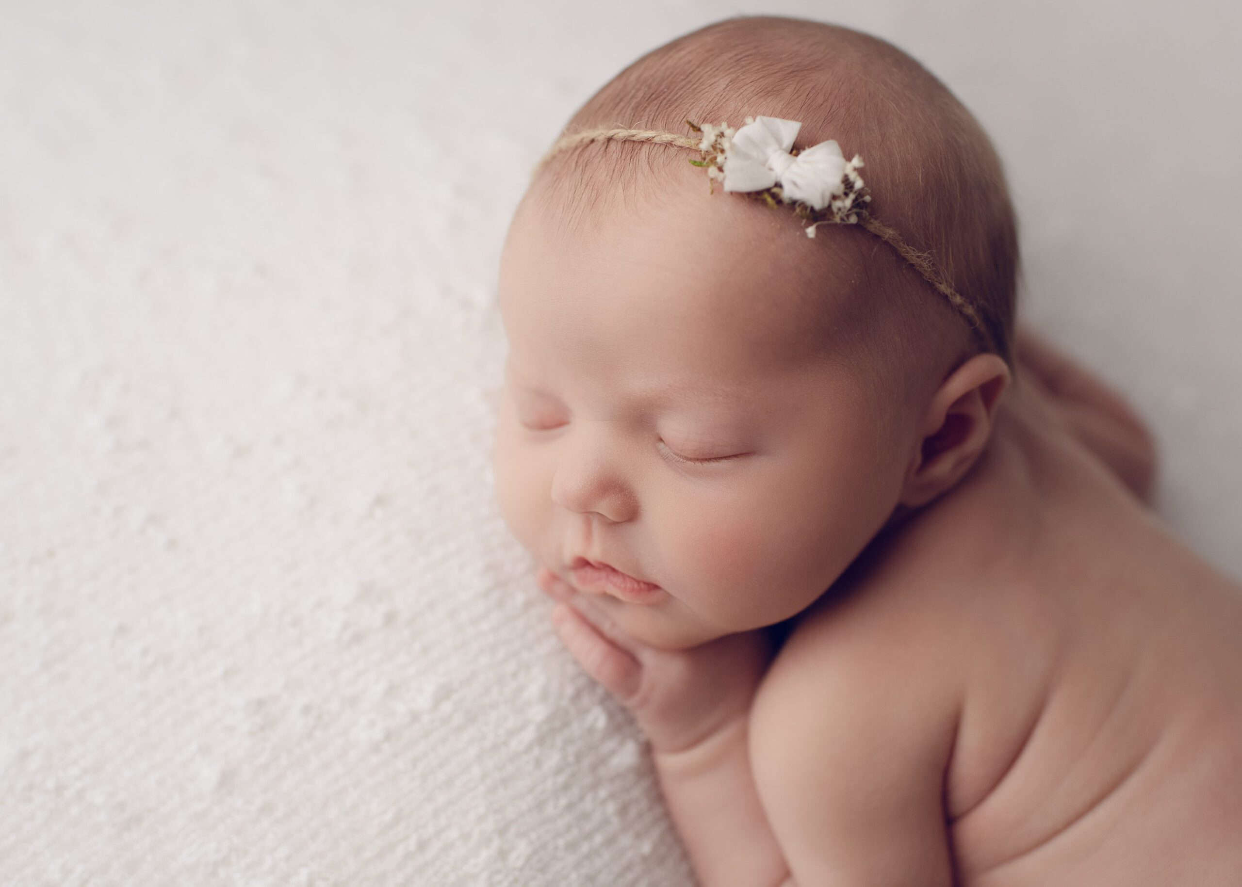 newborn baby laying asleep on white blanket - newborn photography by Molly Carlsen in Birmingham AL